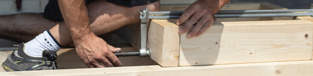 person clamping wood together