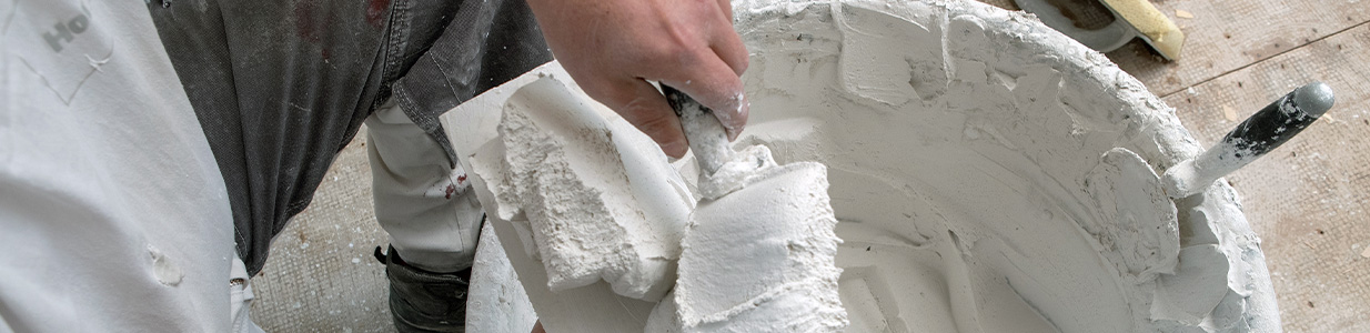 worker preparing plaster in a bucket