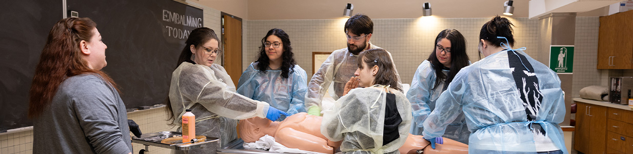 funeral service students learning to embalm using a dummy