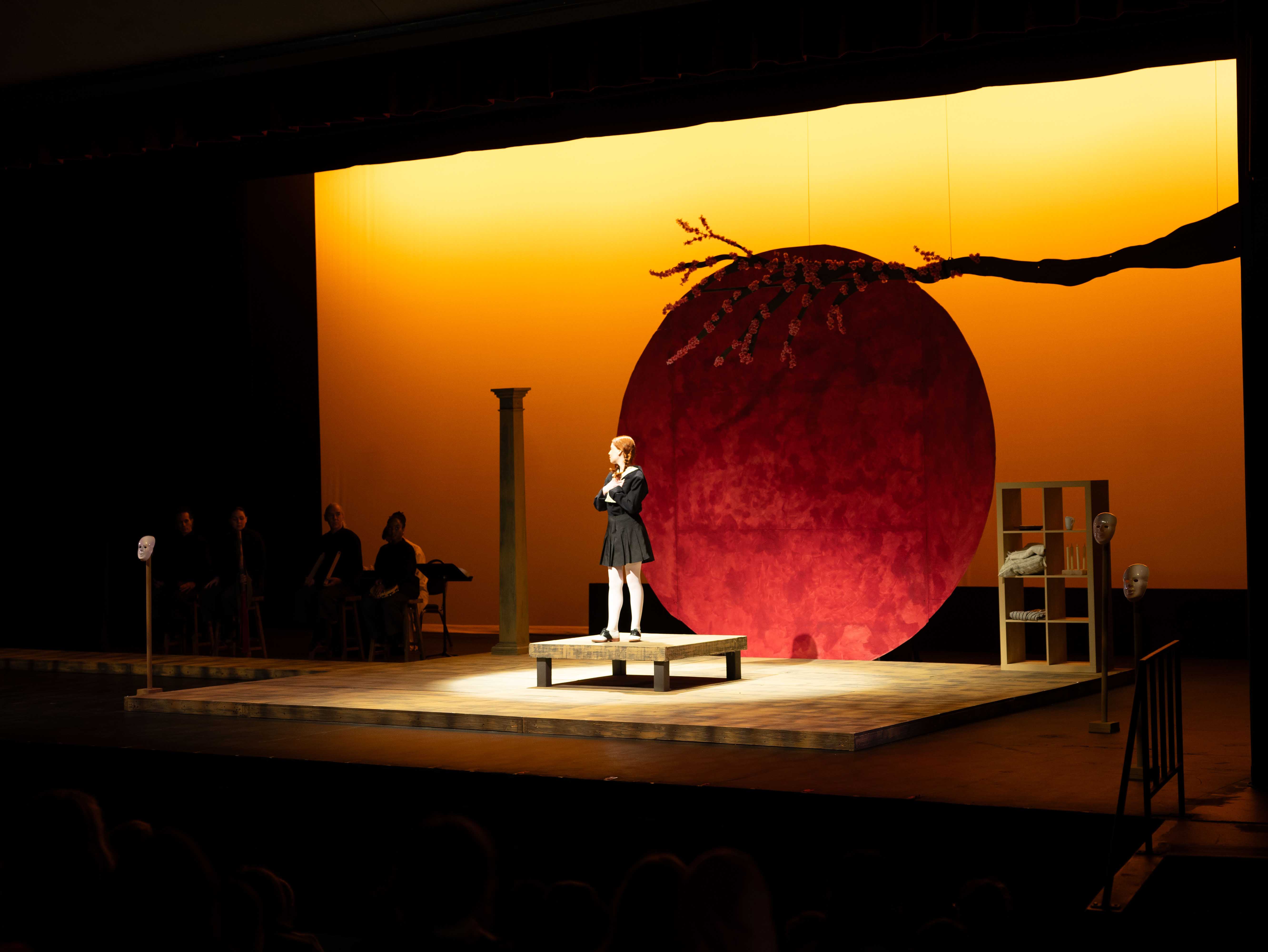 Person on stage before a large orb