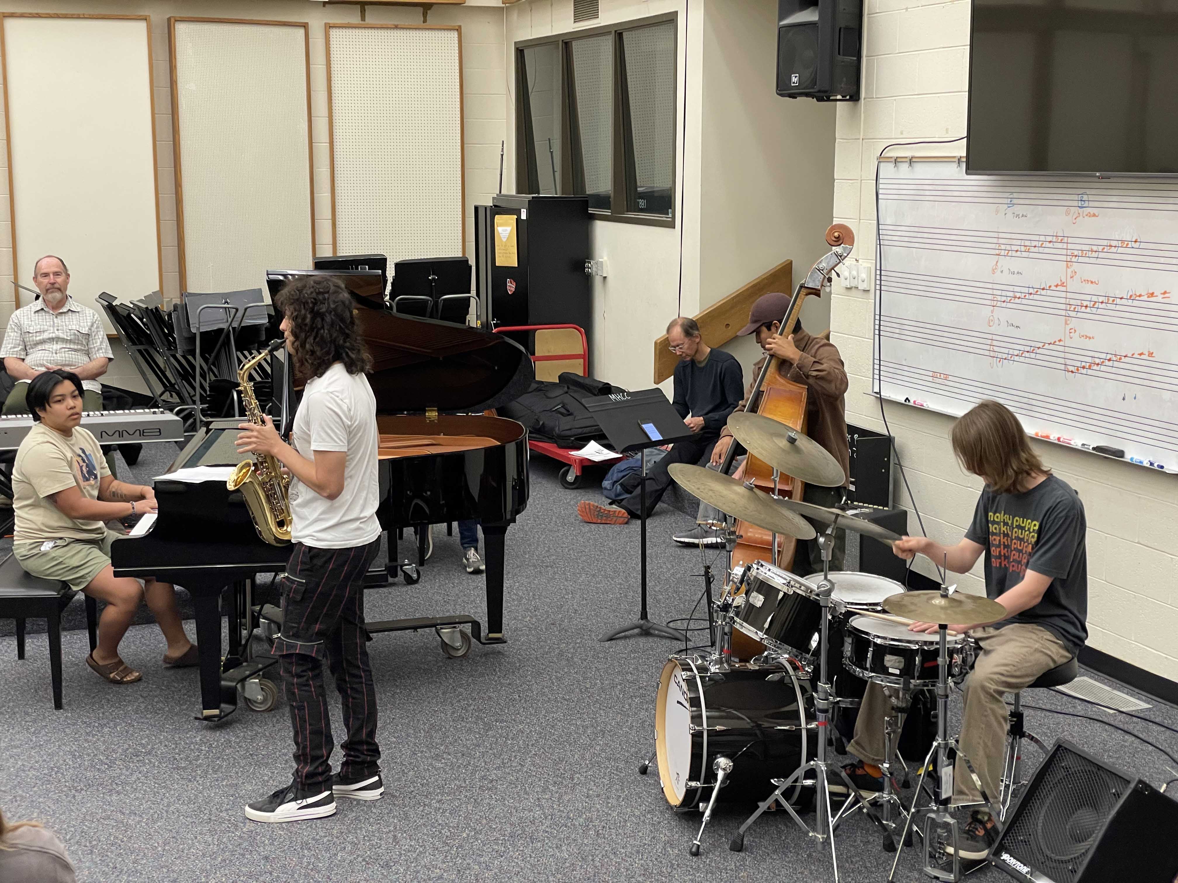 Saxophone, drums, piano, bass and band practicing